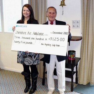 Kerry Garner collecting a cheque on behalf of The Yorkshire Air Ambulance from Ben Rhydding Golf Club captain Neville Beard